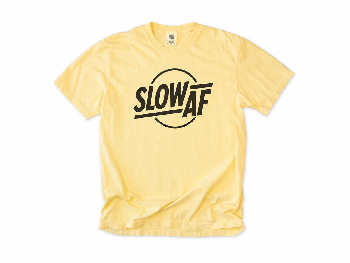 Funny cycling T-shirt in Butter, 'Slow AF' in bold letters inside a circle, for relaxed riders