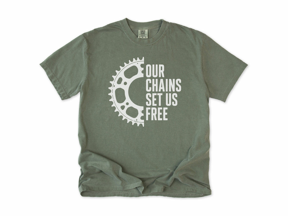 Funny cycling T-shirt in Moss, 'Our Chains Set Us Free' beside a chainring, for cyclists