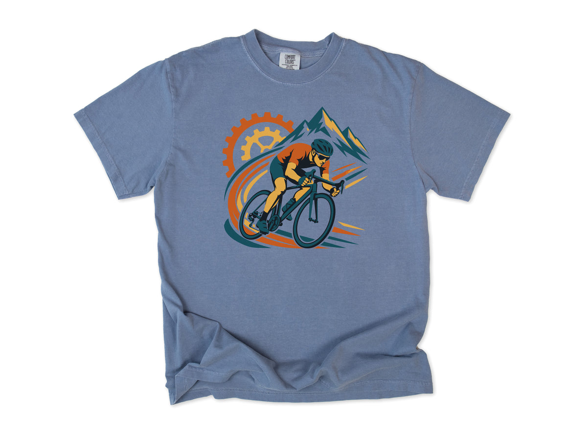 Cycling T-shirt in Blue Jean, a cyclist before a chainring and mountains with orange swooshes, for road cyclists