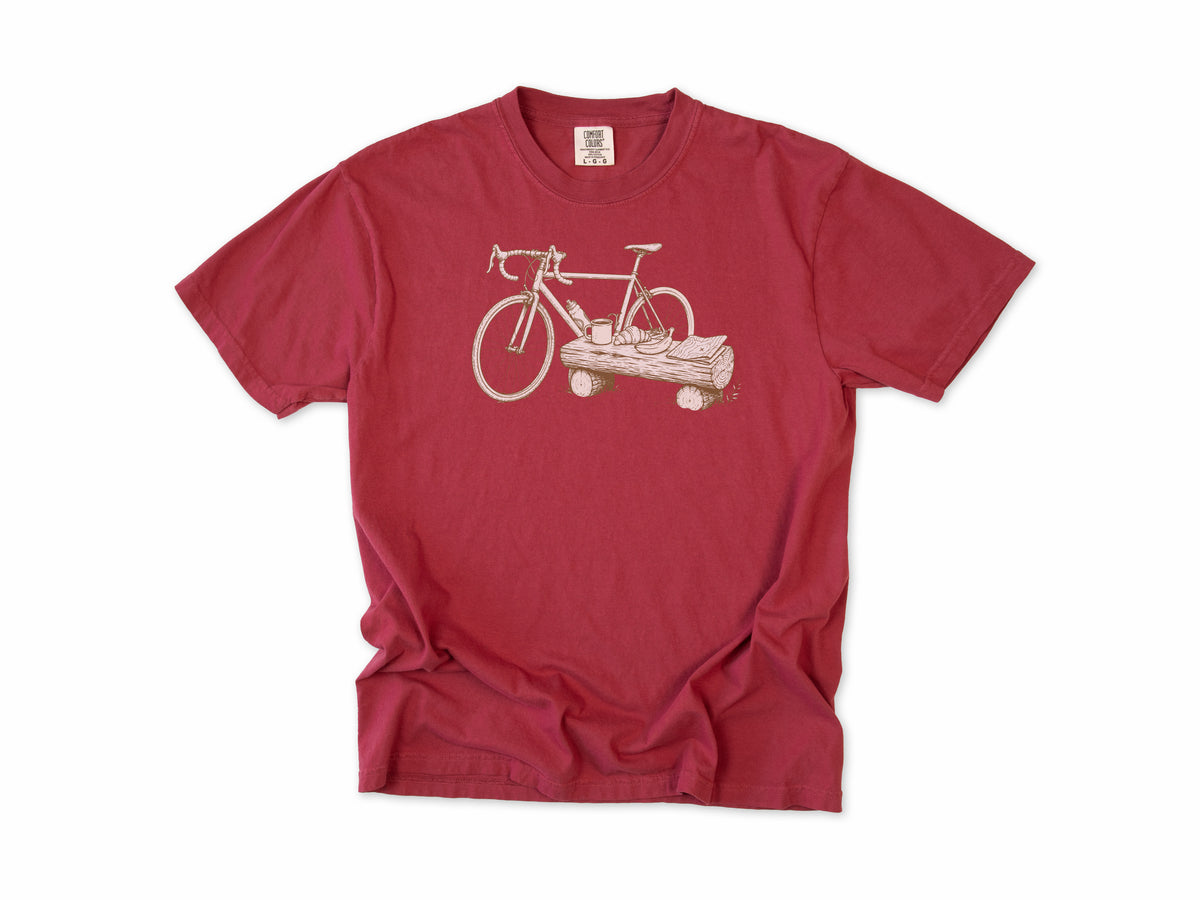 Funny cycling T-shirt in Chili, a bike propped on a log with a drink, for gravel and trail riders