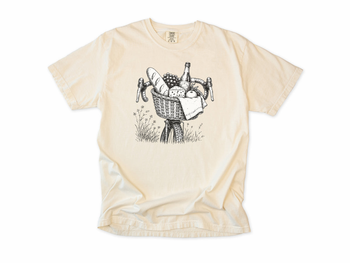 Cycling T-shirt in Ivory, a bike basket with a baguette, cheese and wine, line drawing, for leisure and cafe cyclists