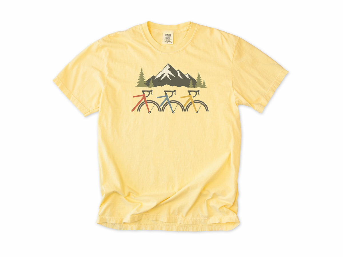 Cycling T-shirt in Butter, three cropped bikes under a snowy mountain, for road and mountain bikers