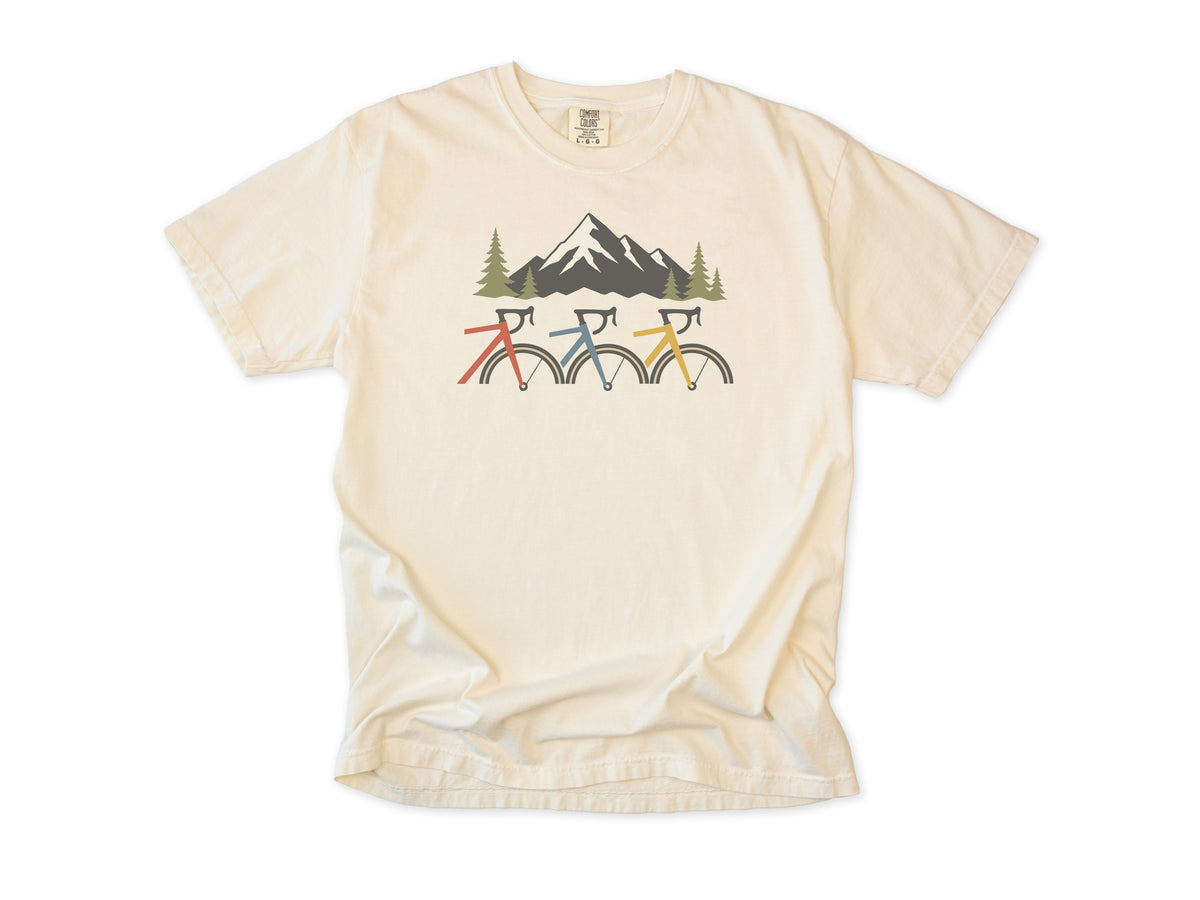 Cycling T-shirt in Ivory, three cropped bikes under a snowy mountain, for road and mountain bikers