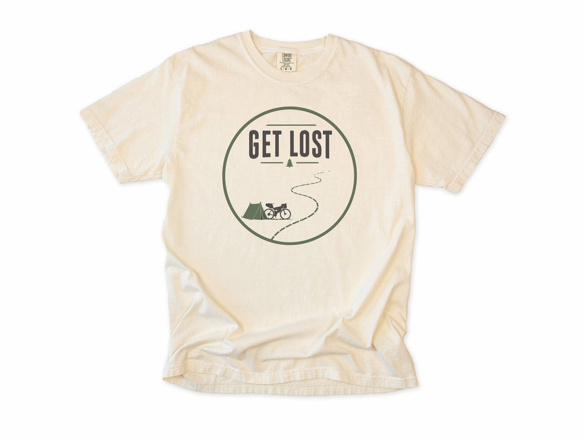 Cycling T-shirt in Ivory, a 'Get Lost' circle with a tent, a bike and a winding trail, for bikepacking and gravel riders
