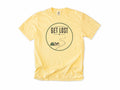 Cycling T-shirt in Butter, a 'Get Lost' circle with a tent, a bike and a winding trail, for bikepacking and gravel riders