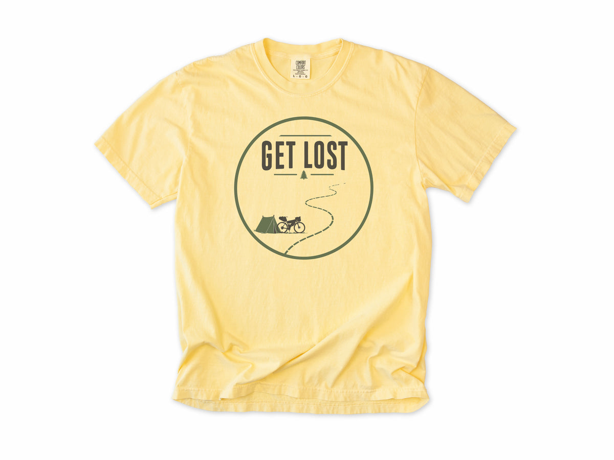 Cycling T-shirt in Butter, a 'Get Lost' circle with a tent, a bike and a winding trail, for bikepacking and gravel riders