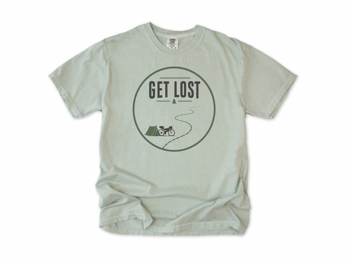 Cycling T-shirt in Bay, a 'Get Lost' circle with a tent, a bike and a winding trail, for bikepacking and gravel riders
