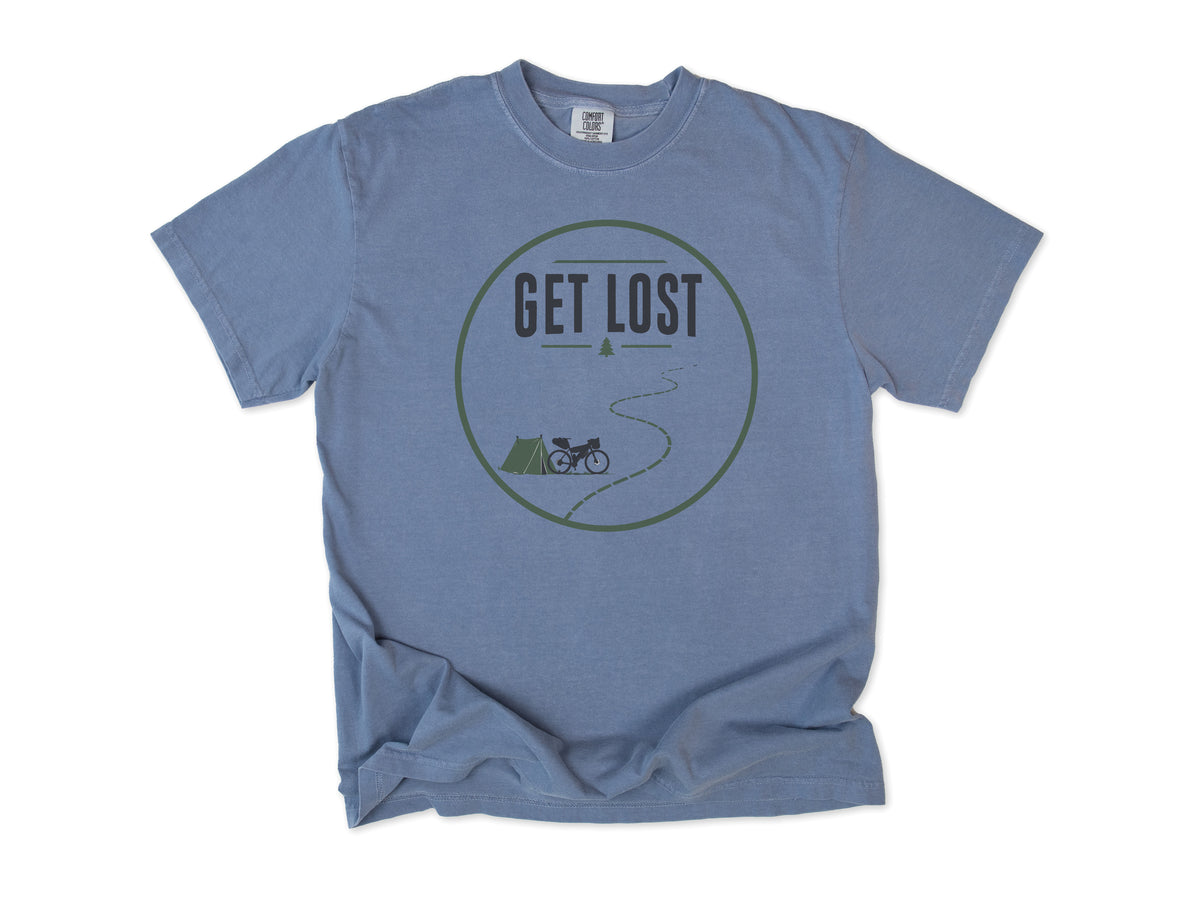 Cycling T-shirt in Blue Jean, a 'Get Lost' circle with a tent, a bike and a winding trail, for bikepacking and gravel riders
