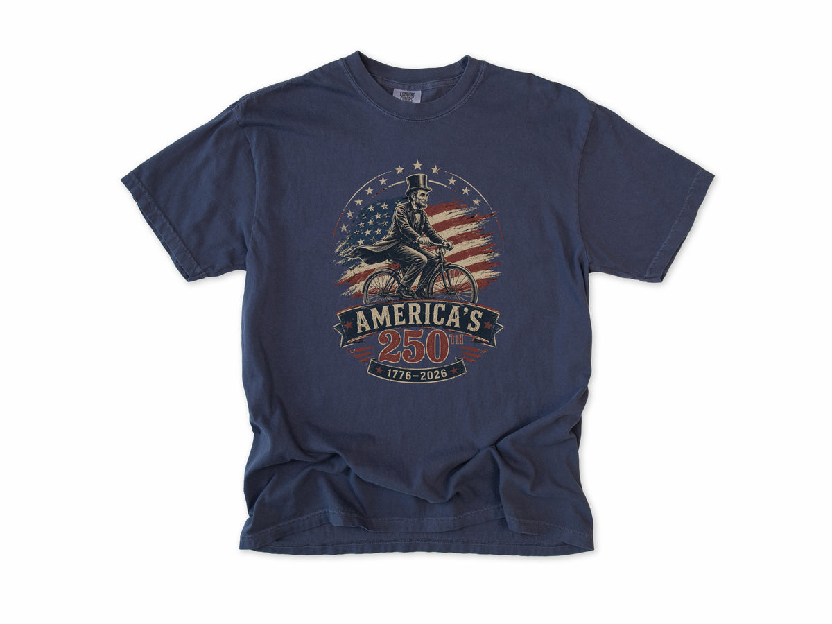 Cycling T-shirt in Navy, Abe Lincoln Bike: Abraham Lincoln riding a bike before the US flag, America 250 and 4th of July gift for cyclists