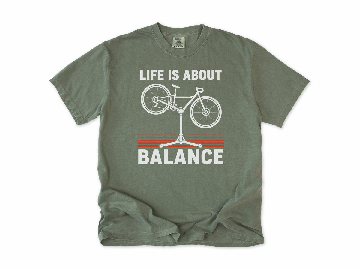 Funny cycling T-shirt in Moss, 'Life Is About Balance' with a bike on a repair stand, for cyclists and bike mechanics