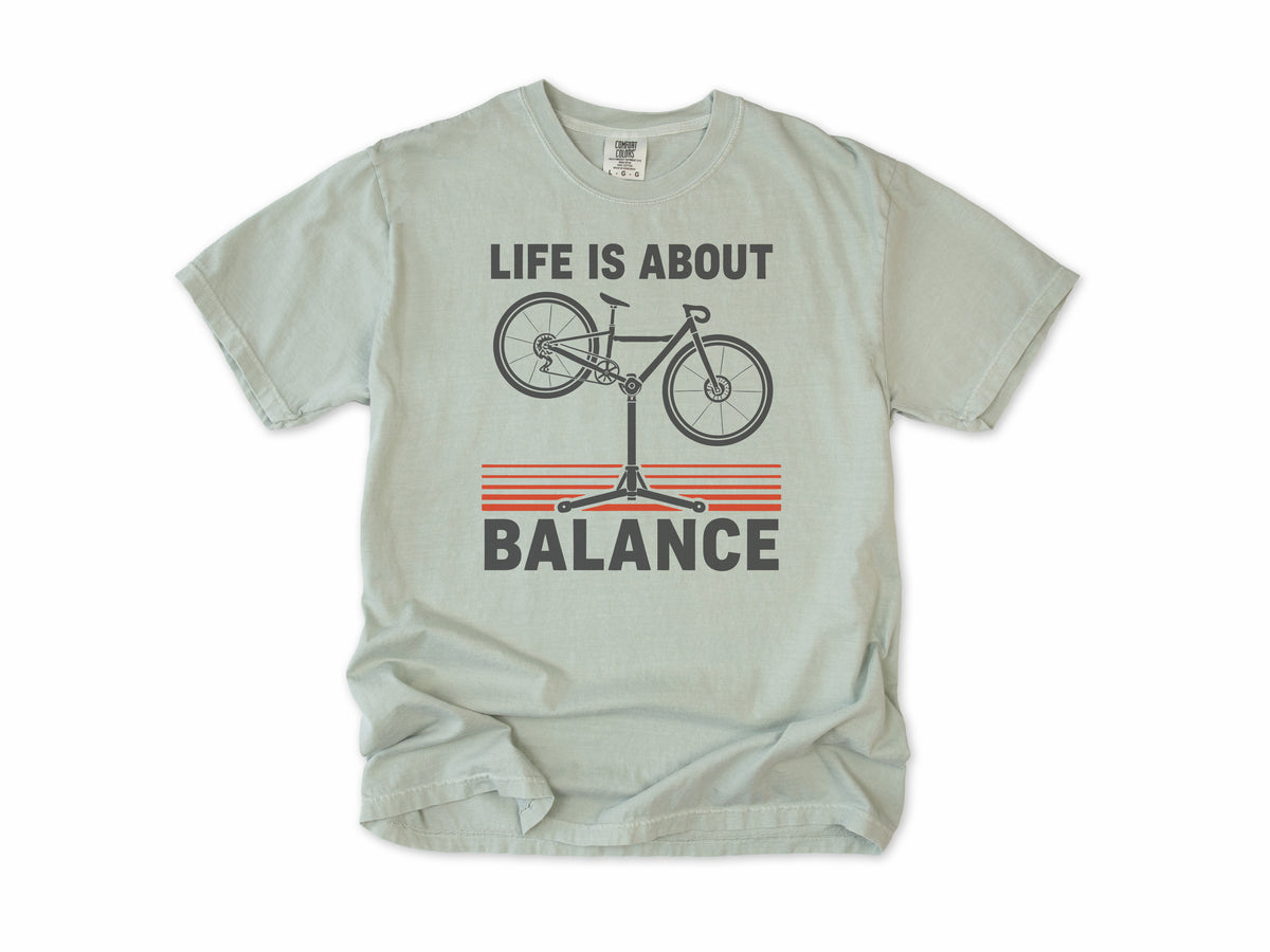 Funny cycling T-shirt in Bay, 'Life Is About Balance' with a bike on a repair stand, for cyclists and bike mechanics