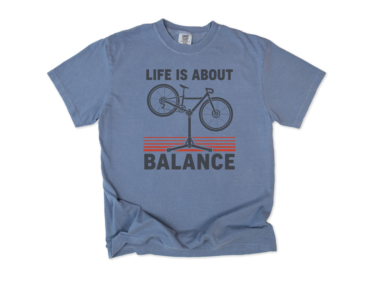 Funny cycling T-shirt in Blue Jean, 'Life Is About Balance' with a bike on a repair stand, for cyclists and bike mechanics