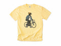 Funny cycling T-shirt in Butter, Casual Bear: a bear in a beanie and denim jacket walking a city bike, for relaxed everyday riders