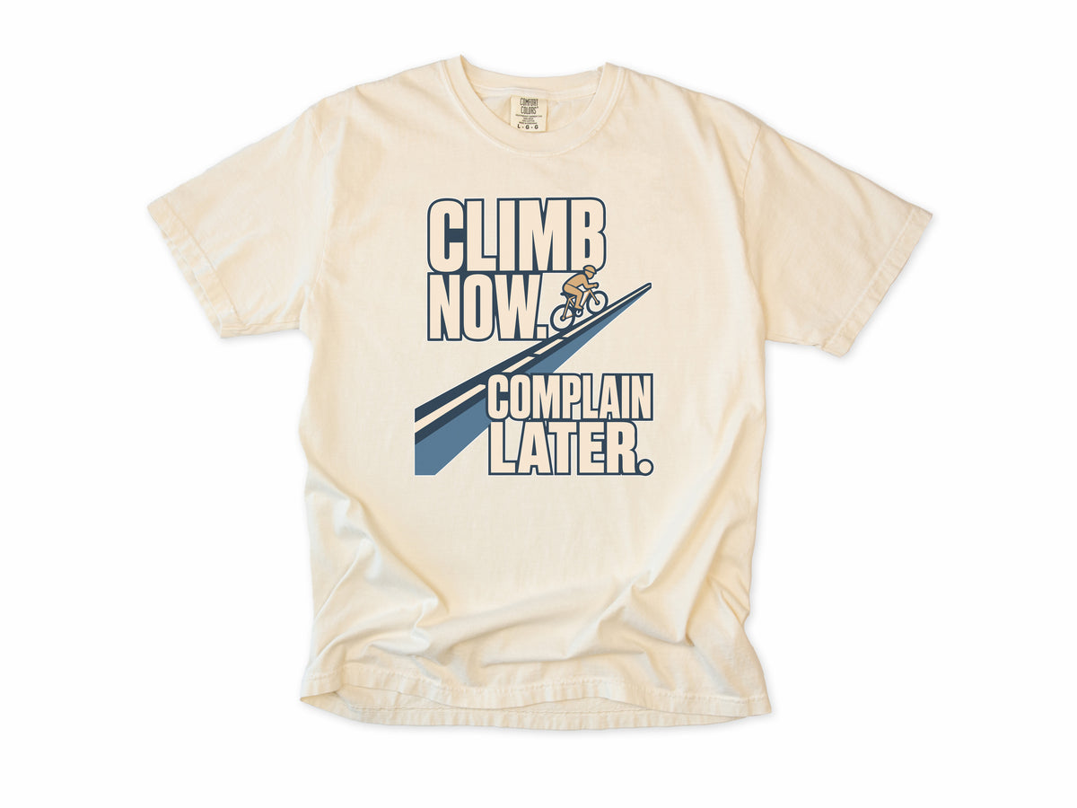 Funny cycling T-shirt in Ivory, 'Climb Now, Complain Later' with a cyclist on a hill, for climbers
