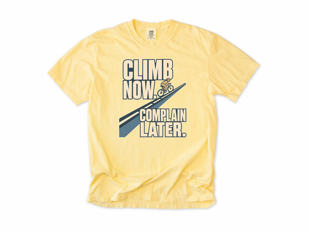 Funny cycling T-shirt in Butter, 'Climb Now, Complain Later' with a cyclist on a hill, for climbers