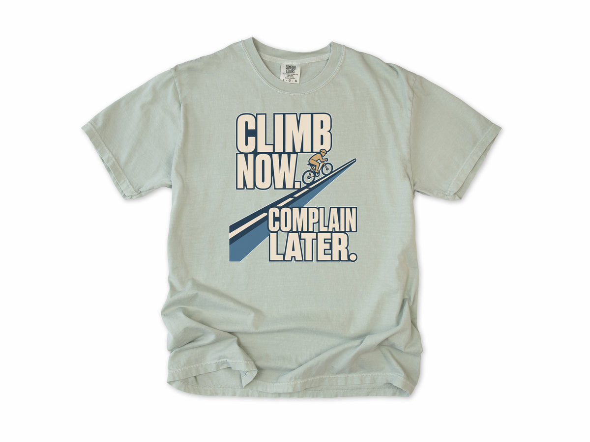 Funny cycling T-shirt in Bay, 'Climb Now, Complain Later' with a cyclist on a hill, for climbers