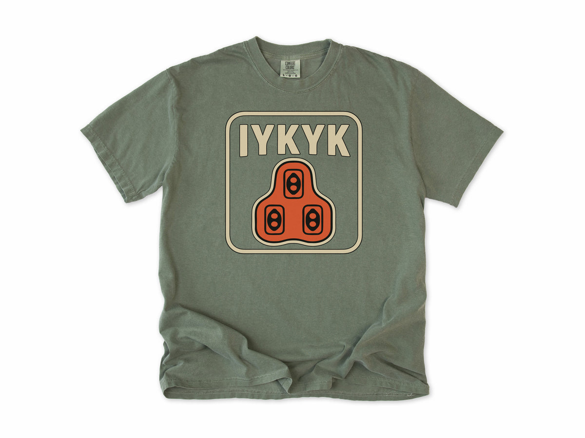 Funny cycling T-shirt in Moss, 'IYKYK' with an orange road bike cleat, for riders who use clipless pedals