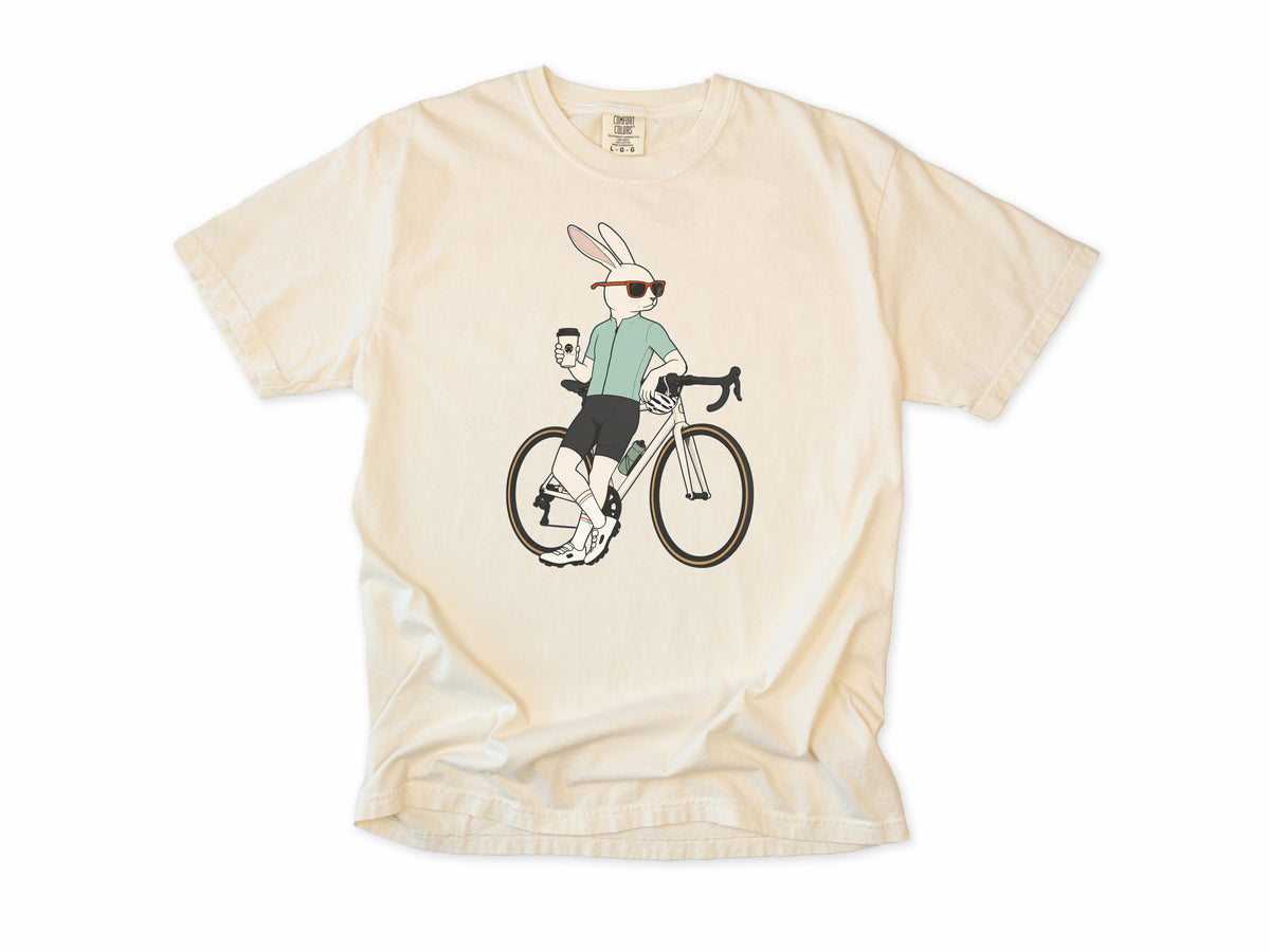 Cycling T-shirt in Ivory, a hare in sunglasses with a coffee, leaning on a road bike, for coffee-loving road cyclists