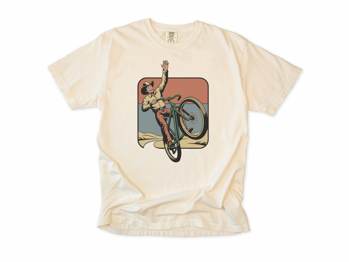 Cycling T-shirt in Ivory, Cycling Cowboy: a cowboy doing a wheelie on a bike, in a desert square, for mountain bikers