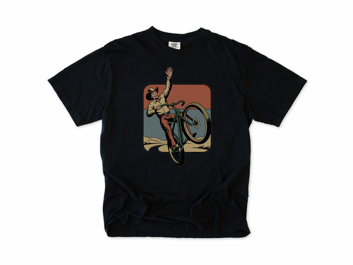 Cycling T-shirt in Black, Cycling Cowboy: a cowboy doing a wheelie on a bike, in a desert square, for mountain bikers