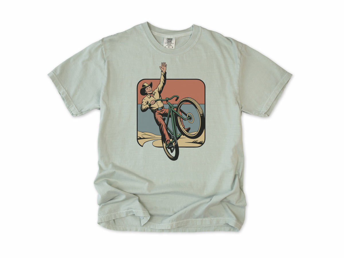 Cycling T-shirt in Bay, Cycling Cowboy: a cowboy doing a wheelie on a bike, in a desert square, for mountain bikers