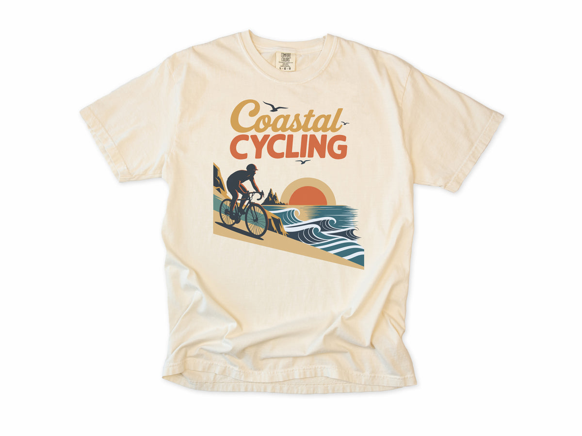 Cycling T-shirt in Ivory, 'Coastal Cycling', a cyclist by the sea at sunset, for cyclists who ride the coast