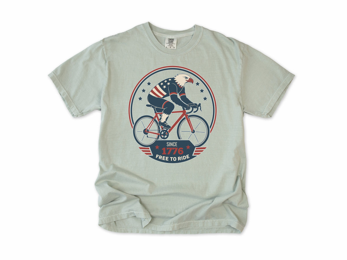 Cycling T-shirt in Bay, a bald eagle in stars and stripes riding a bike, America 250 and 4th of July gift for cyclists