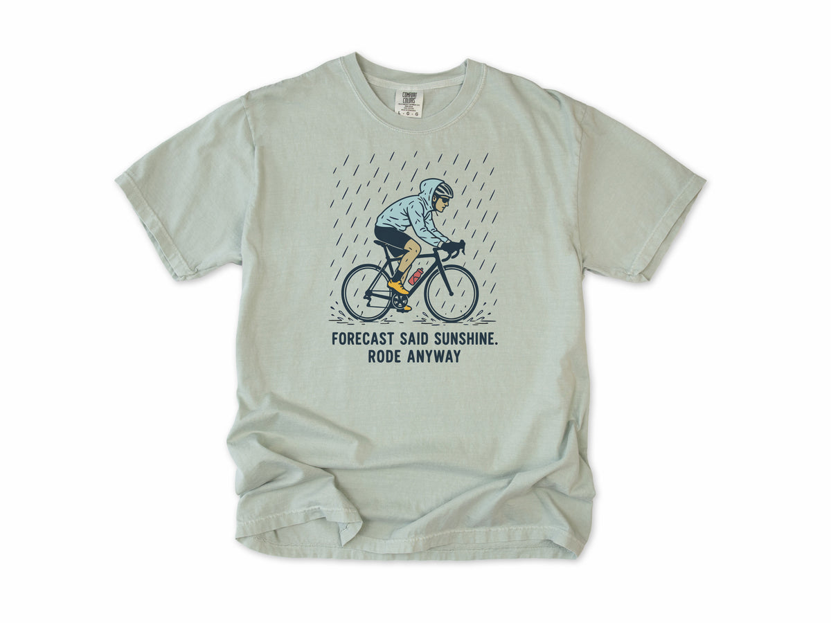 Funny cycling T-shirt in Bay, a cyclist in the rain, 'Forecast said sunshine. Rode anyway', for all-weather riders