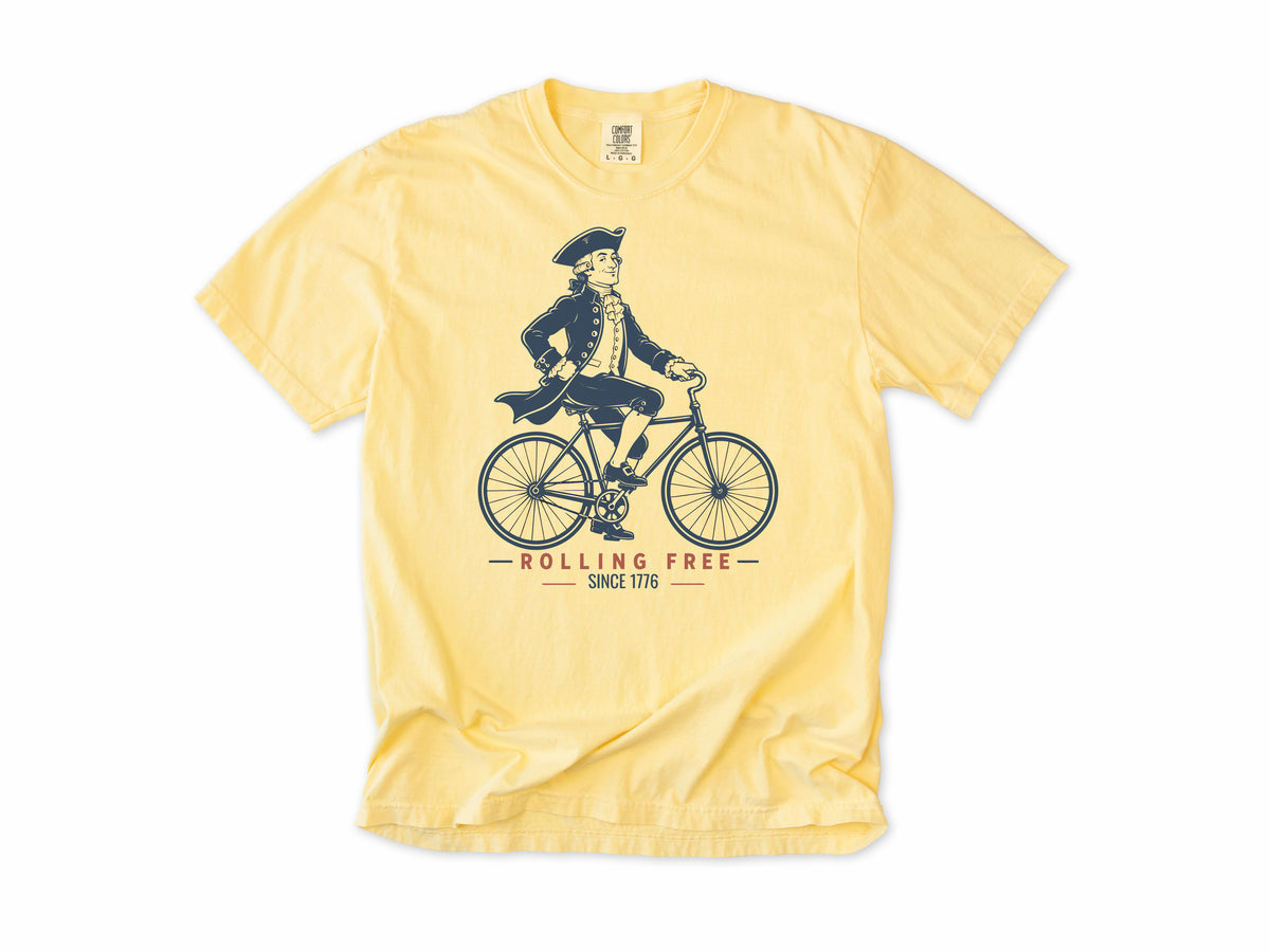 Cycling T-shirt in Butter, Founding Father: a colonial gentleman in a tricorn hat riding a bike, America 250 and 4th of July gift for cyclists