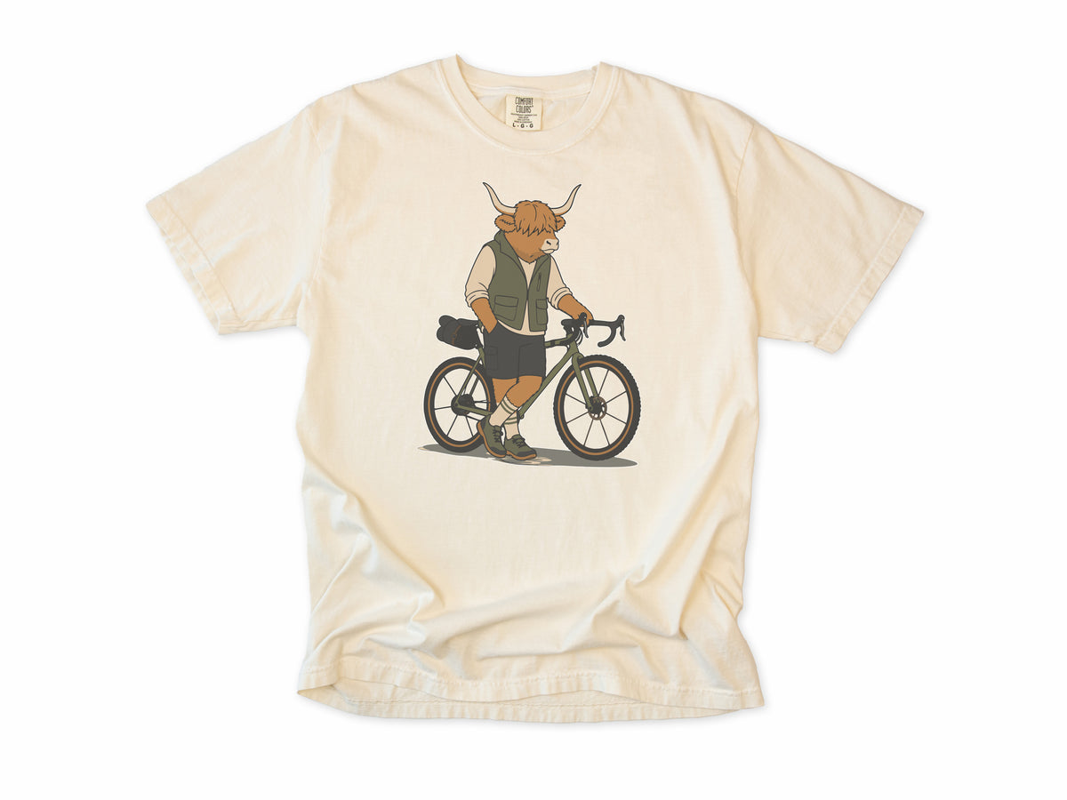 Cycling T-shirt in Ivory, a Highland cow in a vest standing beside a gravel bike, for gravel riders