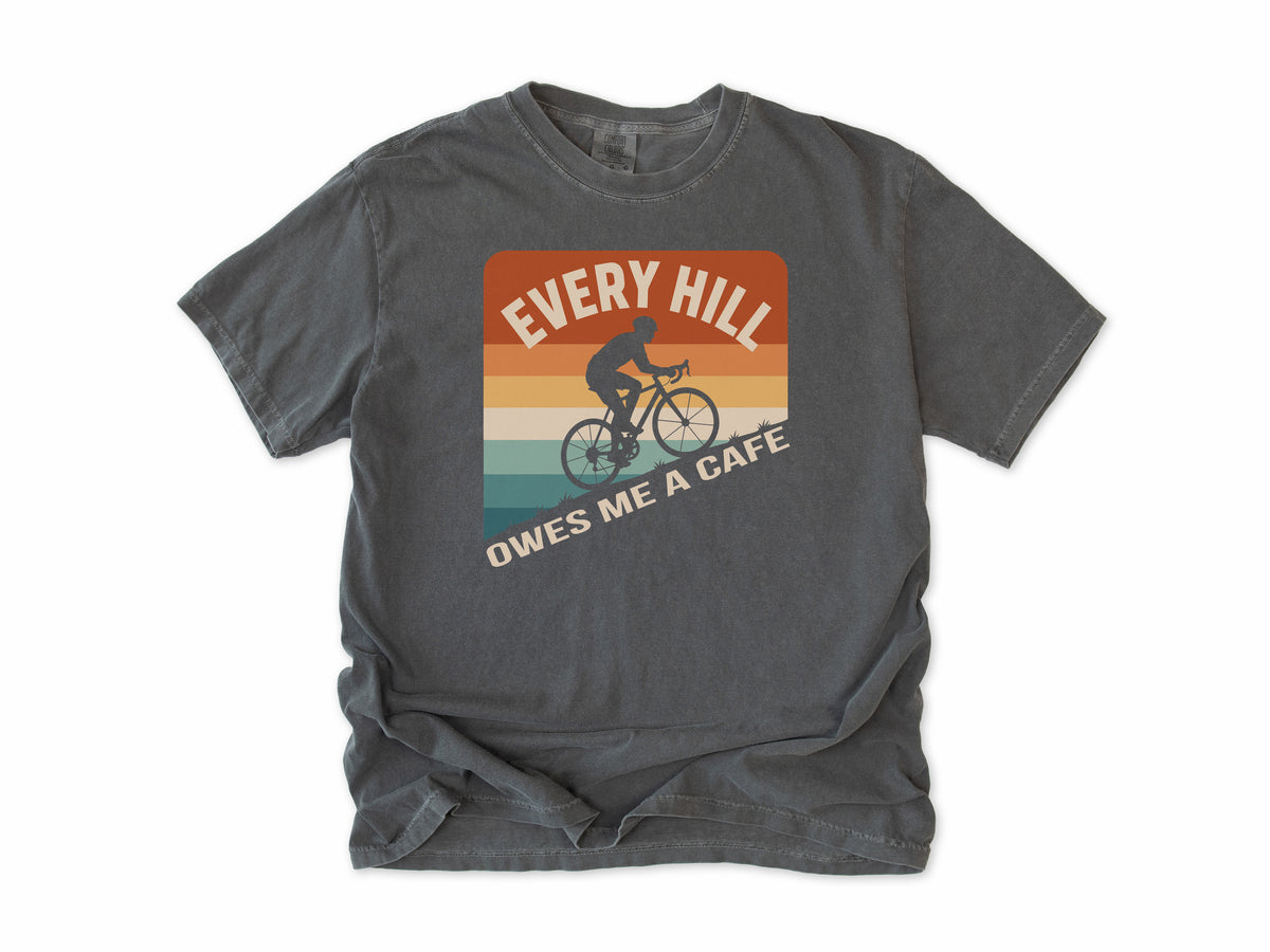 Funny cycling T-shirt in Pepper, 'Every Hill Owes Me a Cafe', a cyclist on retro stripes, for riders who ride for coffee