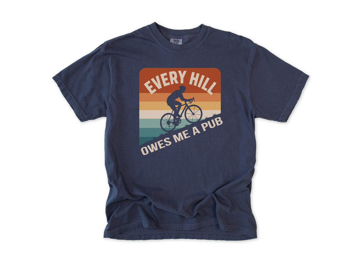 Funny cycling T-shirt in Navy, 'Every Hill Owes Me a Pub', a cyclist on retro stripes, for riders who ride for the pub