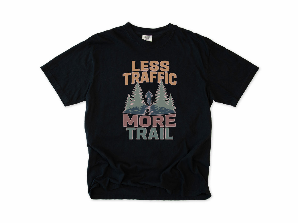 Cycling T-shirt in Black, 'Less Traffic More Trail' with a rider between pine trees, for mountain bikers
