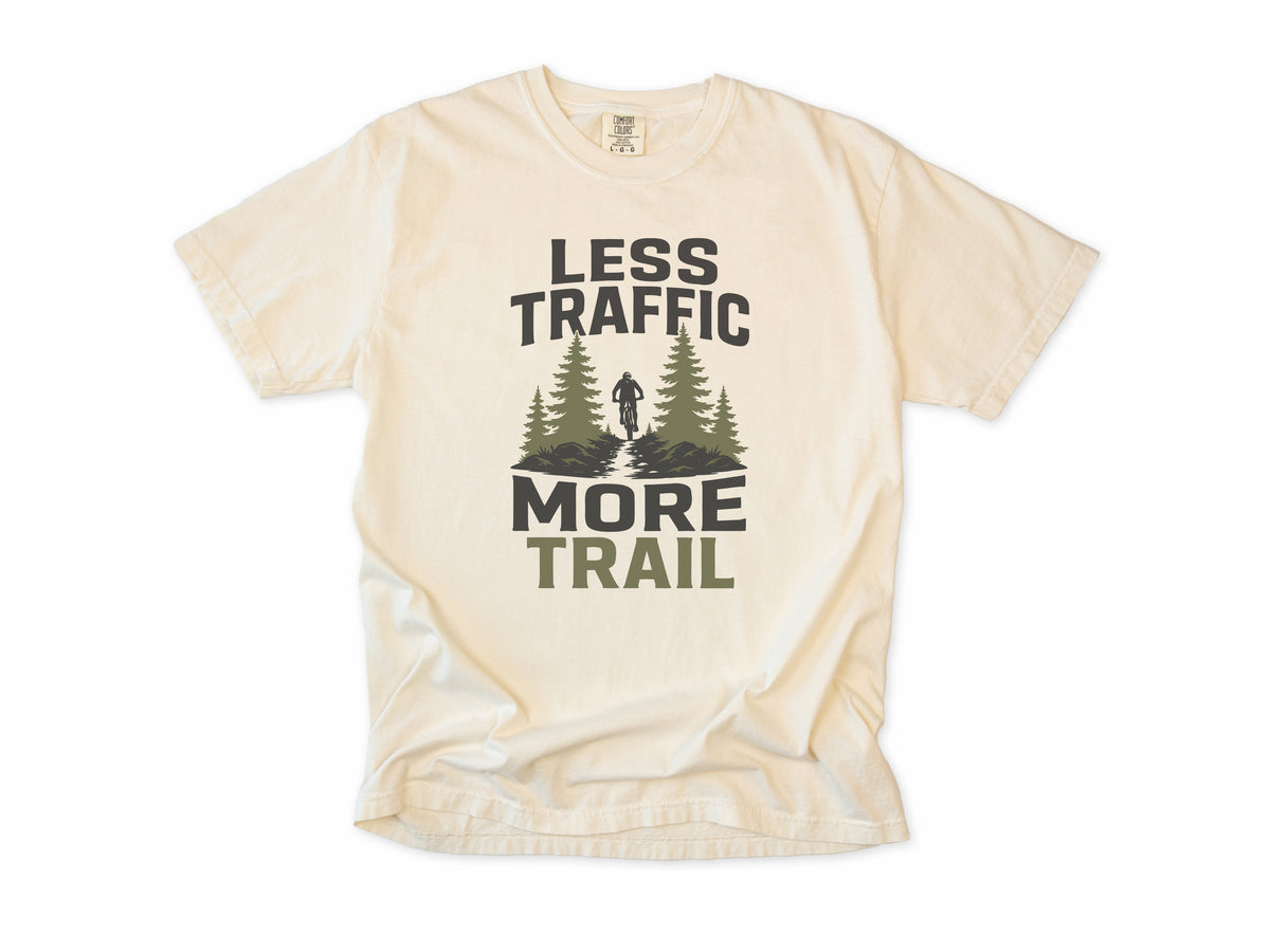 Cycling T-shirt in Ivory, 'Less Traffic More Trail' with a rider between pine trees, for mountain bikers