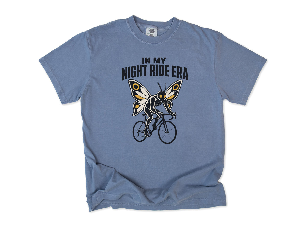 Funny cycling T-shirt in Blue Jean, Mothman Single: 'In my night ride era', a moth-winged figure riding a bike, for night riders