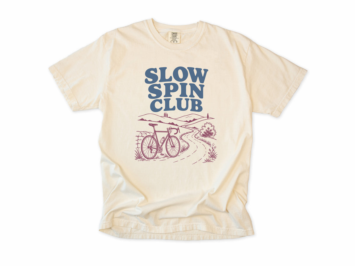 Cycling T-shirt in Ivory, 'Slow Spin Club' with a bike on a winding country lane, for relaxed riders