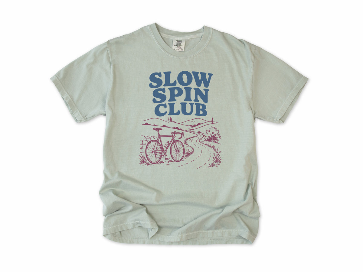 Cycling T-shirt in Bay, 'Slow Spin Club' with a bike on a winding country lane, for relaxed riders