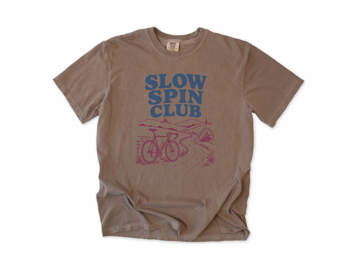 Cycling T-shirt in Espresso, 'Slow Spin Club' with a bike on a winding country lane, for relaxed riders