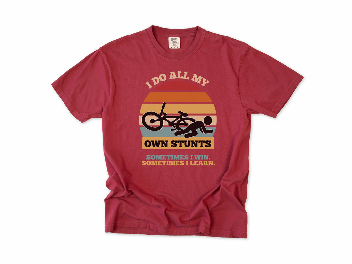 Funny cycling T-shirt in Chili, 'I Do All My Own Stunts', a crashed rider on retro sunset stripes, for mountain bikers