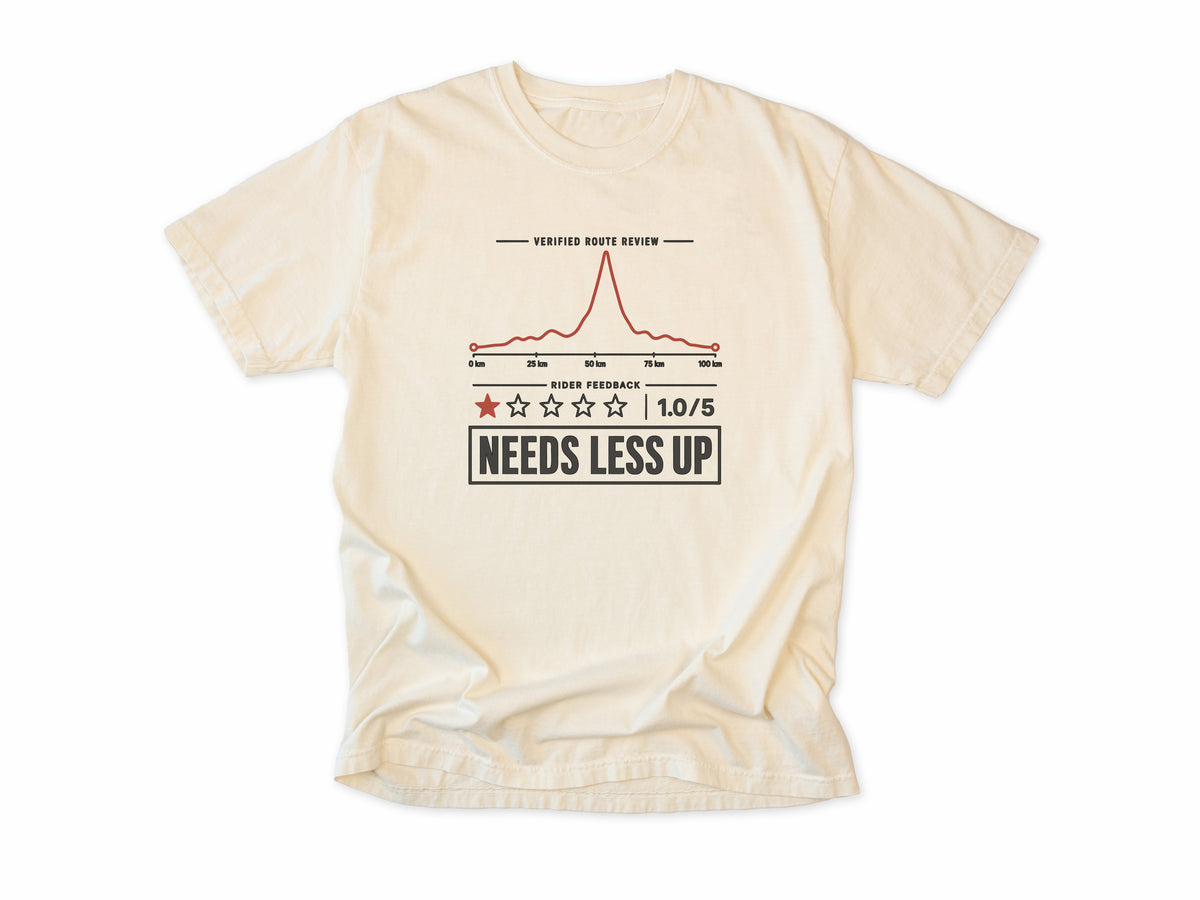 Funny cycling T-shirt in Ivory, a one-star route review, 'Needs Less Up', for riders who prefer flat rides